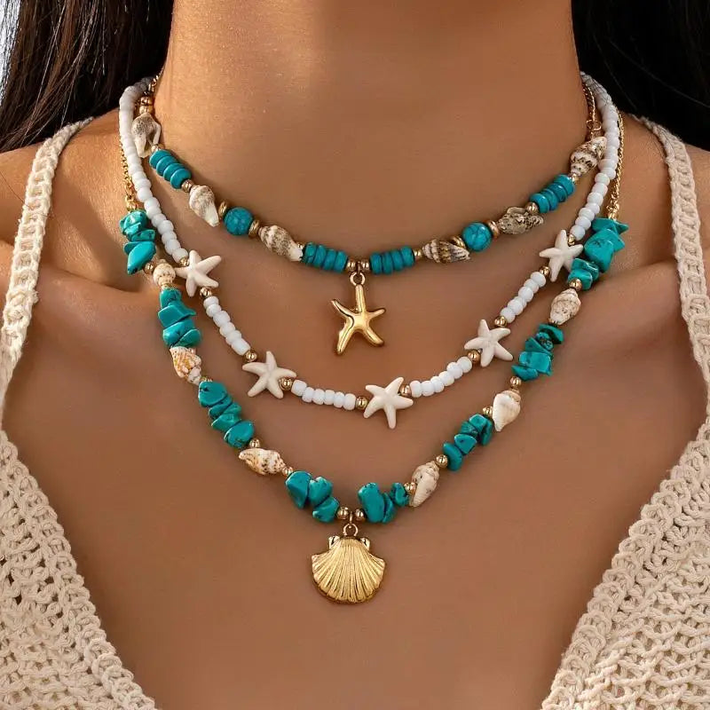 A three-layered beaded necklace set with turquoise, white, and gold elements, including starfish and seashell charms, shown on a model's neck | DIVINE TIMES by Shopp Java